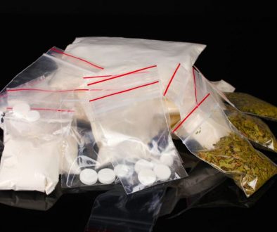 Cocaine and marihuana in packages on black background