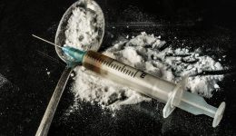 Drug syringe and cooked heroin on spoon